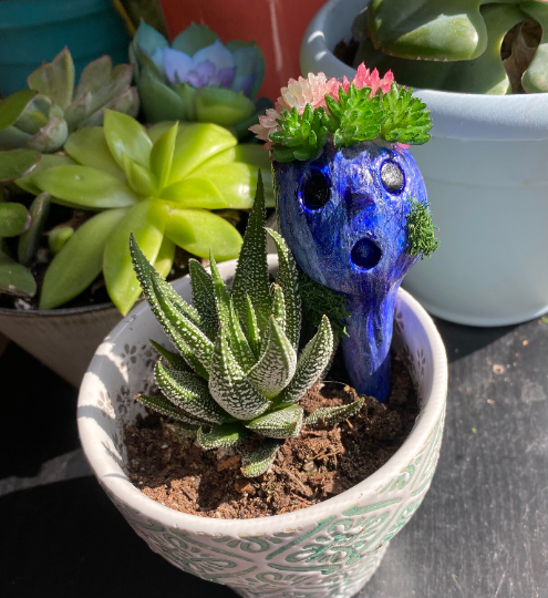 creepy sculpture in plant pot